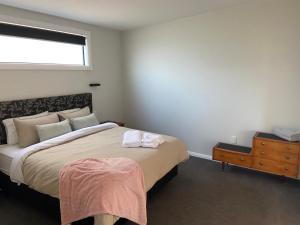 a bedroom with a bed and a dresser and a window at The Jam Shed in Waimate