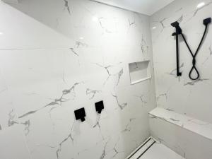 a bathroom with white marble walls and white fixtures at Forest view guesthouse in Runcorn +12 photos