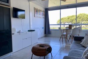 a living room with a couch and a table at Le Studio de la Lagune studio cabine proche de la plage in Le Grau-du-Roi