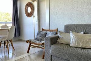 a living room with a couch and a table at Le Studio de la Lagune studio cabine proche de la plage in Le Grau-du-Roi