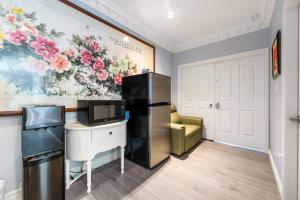 una stanza con frigorifero, scrivania e sedia di Amy Guesthouse a Richmond Altre 43 foto