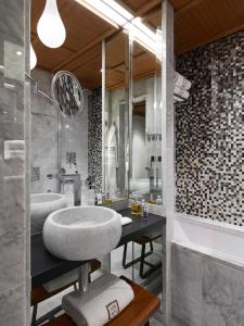 a bathroom with a sink, mirror, and bathtub at Hotel Montalembert in Paris