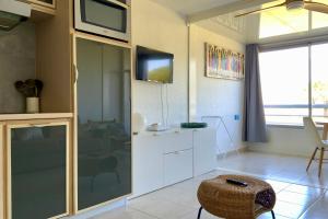 a living room with a television and a table at Le Studio de la Lagune studio cabine proche de la plage in Le Grau-du-Roi +27 photos
