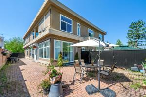 un patio con tavolo, sedie e un ombrellone di Amy Guesthouse a Richmond