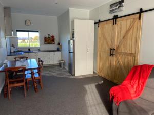 a kitchen with a table and a sliding barn door at The Jam Shed in Waimate