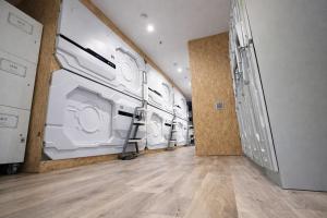 a laundry room with several washing machines in it at Space Q Capsule Hotel in Sydney