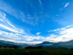 a blue sky with clouds over a green field at Amplio y cómodo departamento. in Loja