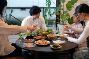 a group of people sitting around a table eating food at goemon-inn in Akita