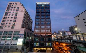 a tall building in the middle of a city at Hotel Corner Inn in Pyeongtaek