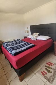 a bed with a red blanket and pillows on it at Algarrobo, Pinares de Canelillo in Algarrobo +77 photos