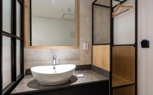 a bathroom with a white sink on a counter at Hotel Corner Inn in Pyeongtaek