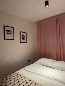 a bedroom with a bed and two pictures on the wall at Bello departamento centrico in Valladolid +11 photos