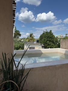 a swimming pool with a view of a house at Bello departamento centrico in Valladolid