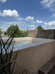 a swimming pool in front of a wooden fence at Bello departamento centrico in Valladolid