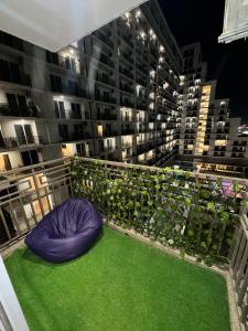 a balcony with a blue bean bag chair on the grass at D Haven Stays in Greater Noida