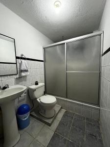 a bathroom with a shower and a toilet and a sink at Amplio y cómodo departamento. in Loja