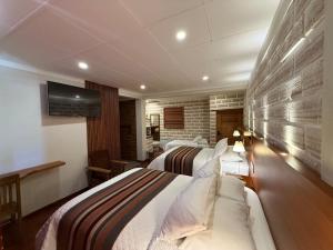 a hotel room with two beds and a flat screen tv at Hotel de Sal Atipax in Uyuni
