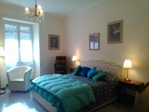 ein Schlafzimmer mit einem Bett mit blauen Kissen und einem Stuhl in der Unterkunft Il Vostro Comfort in Rom