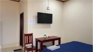 a bedroom with a table and a tv on the wall at khounxub view hotel in Ban Pho Touane +12 photos