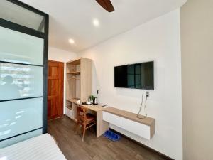 a bedroom with a desk and a tv on a wall at Soleil Crown Boutique in Thôn Trường Giang +21 photos