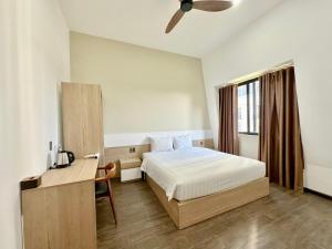 a bedroom with a bed and a desk and a window at Soleil Crown Boutique in Thôn Trường Giang