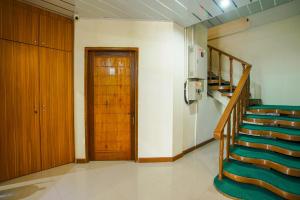 a room with stairs and a door and a kitchen at Capital O 90643 Suri Guest House Syariah in Padang +30 photos