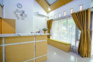 a kitchen with wooden cabinets and a window at Capital O 90643 Suri Guest House Syariah in Padang