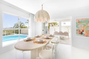a white dining room with a table and chairs at WhitsunStays - The Cyclades in Eimeo +13 photos