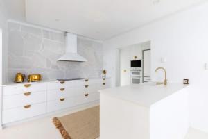 a kitchen with a white counter and a sink at WhitsunStays - The Cyclades in Eimeo