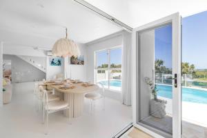 a dining room with a table and a pool at WhitsunStays - The Cyclades in Eimeo