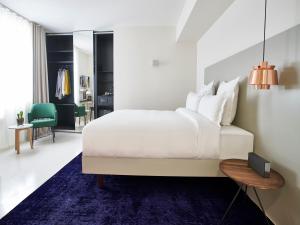 a bedroom with a white bed and a blue rug at 9Hotel Sablon in Brussels