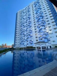 a large apartment building with a pool in front of it at Casa Primo in Biñan