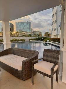 two wicker chairs and a couch on a balcony at Casa Primo in Biñan