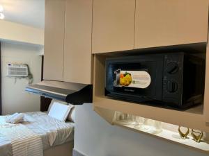 a kitchen with a microwave and a bed at Casa Primo in Biñan