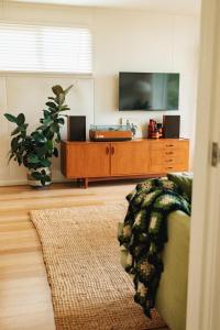 a living room with a tv and a couch at Georgie Bay St Helens in St Helens