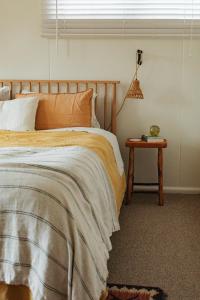 a bedroom with a bed and a table with a lamp at Georgie Bay St Helens in St Helens