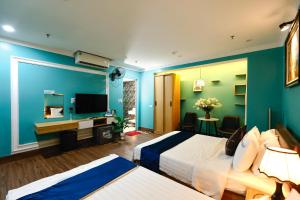 a hotel room with two beds and a flat screen tv at Dream Hotel Hà Nội in Hanoi