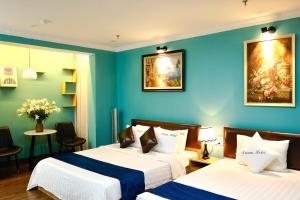 two beds in a room with blue walls at Dream Hotel Hà Nội in Hanoi