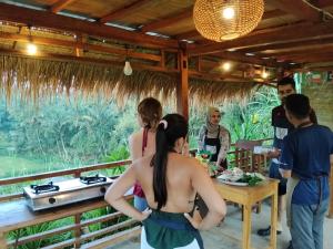 a group of people standing around a table in a restaurant at Girang Rinjani Bungalows in Tetebatu