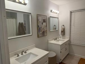 a white bathroom with two sinks and a mirror at Marion Getaway in Marion +32 photos