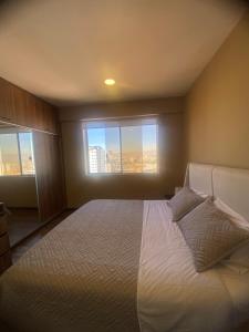 a bedroom with a large bed with a large window at Apartamento céntrico y lujoso in Cochabamba +30 photos