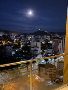 a view of a city at night with a full moon at Apartamento céntrico y lujoso in Cochabamba