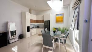 a kitchen and dining room with a table and chairs at Moses Home in Tjilandak