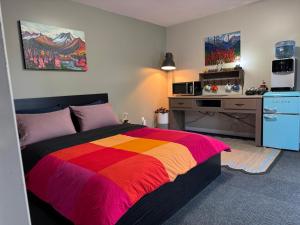a bedroom with a colorful bed and a desk at The Big Red Barn in Whitehorse