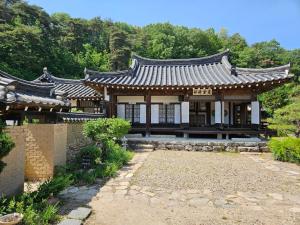 an asian style building with a garden in front of it at Tohyang Traditional House in Bonghwa