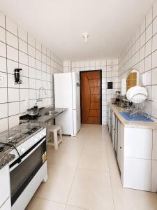 a kitchen with a stove and a refrigerator at Ocean Tower in São Luís