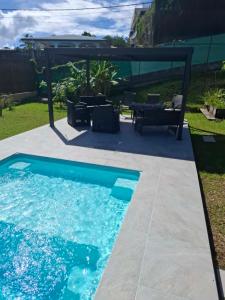 a swimming pool in a backyard with a gazebo at Fare fenua Maison 270m2 12p in Papeete