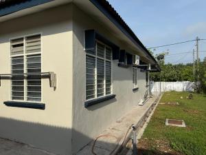 a white house with windows on the side of it at Lanisa Staycation Mesra in Kampong Padang Bungor