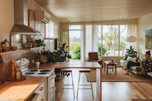 a kitchen and living room with a person sitting on a couch at Georgie Bay St Helens in St Helens