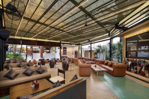 a lobby with couches and tables in a building at Maha Resort Bali in Canggu